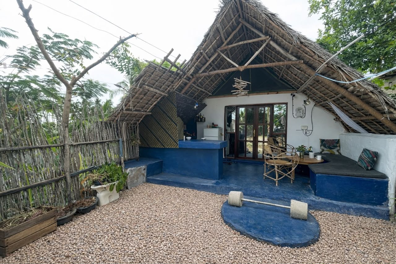 Makuti Banda from the side with blue-painted veranda and barbell