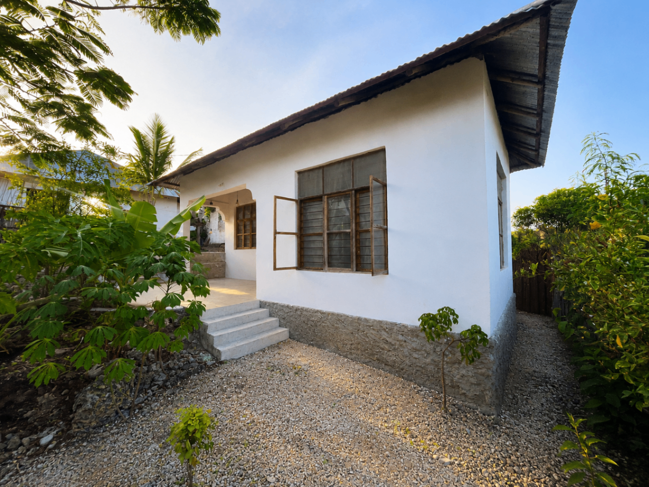 The Garden House exterior with tropical garden surroundings